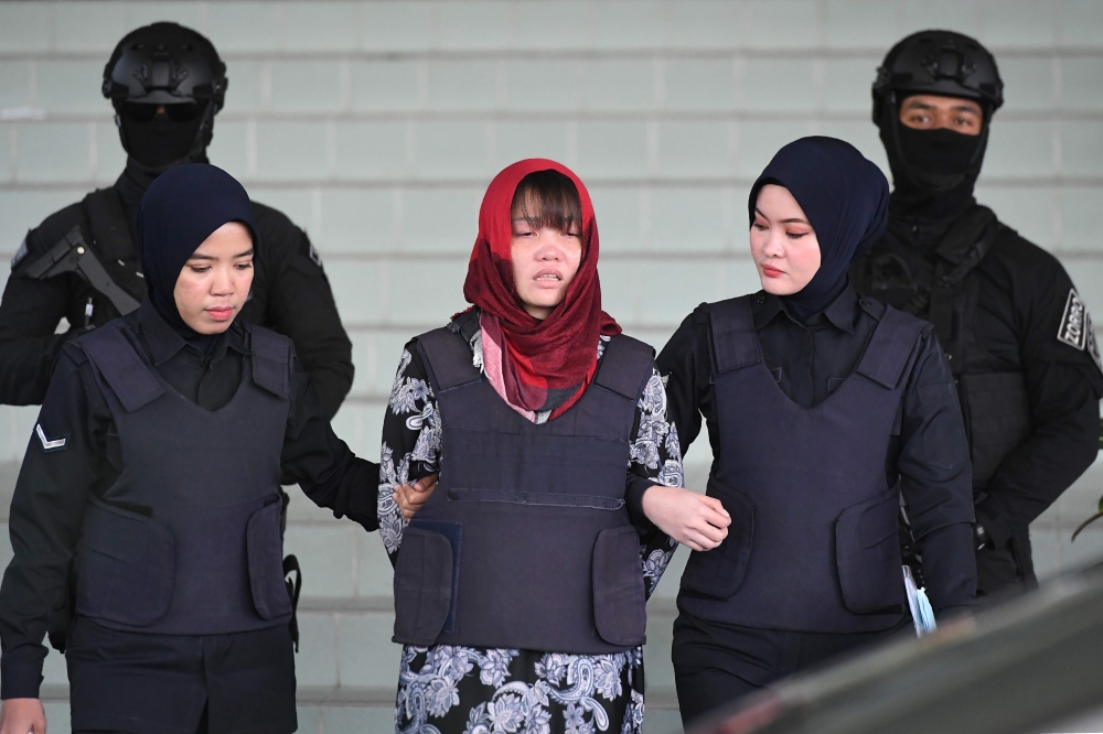 In this file photo taken on March 14, 2019, Vietnamese national Doan Thi Huong (C), accused of murdering Kim Jong Nam, the half brother of North Korean leader Kim Jong Un, leaves Shah Alam High Court escorted by police, outside Kuala Lumpur.  / AFP / MOHD