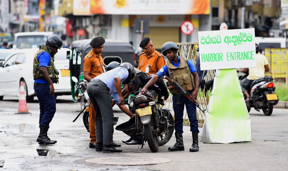 Sri Lankan Navy personnel inspect a motorcycle as they block a road at the harbour in Colombo on May 3, 2019, after a series of bomb blasts targeting churches and luxury hotels on Easter Sunday in Sri Lanka. AFP / Ishara S. Kodikara 