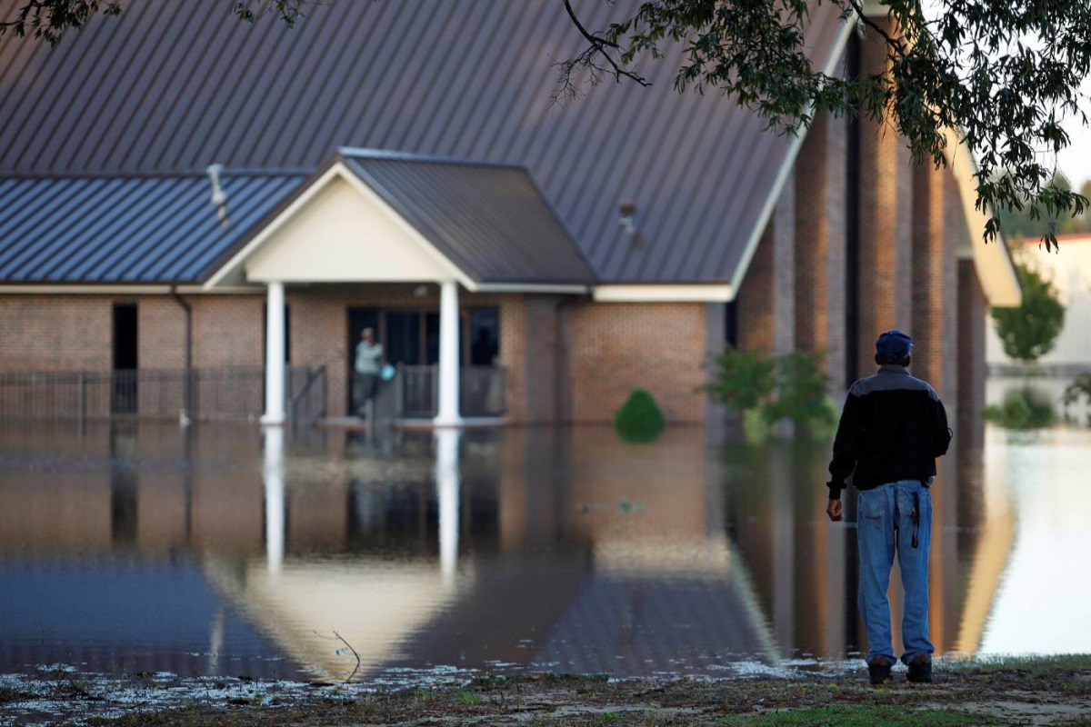 Church member John Batiste checks the flood levels around St. Mark Church of Christ after the effects of Hurricane Matthew in Goldsboro, North Carolina, October 12, 2016. Reuters/Randall Hill