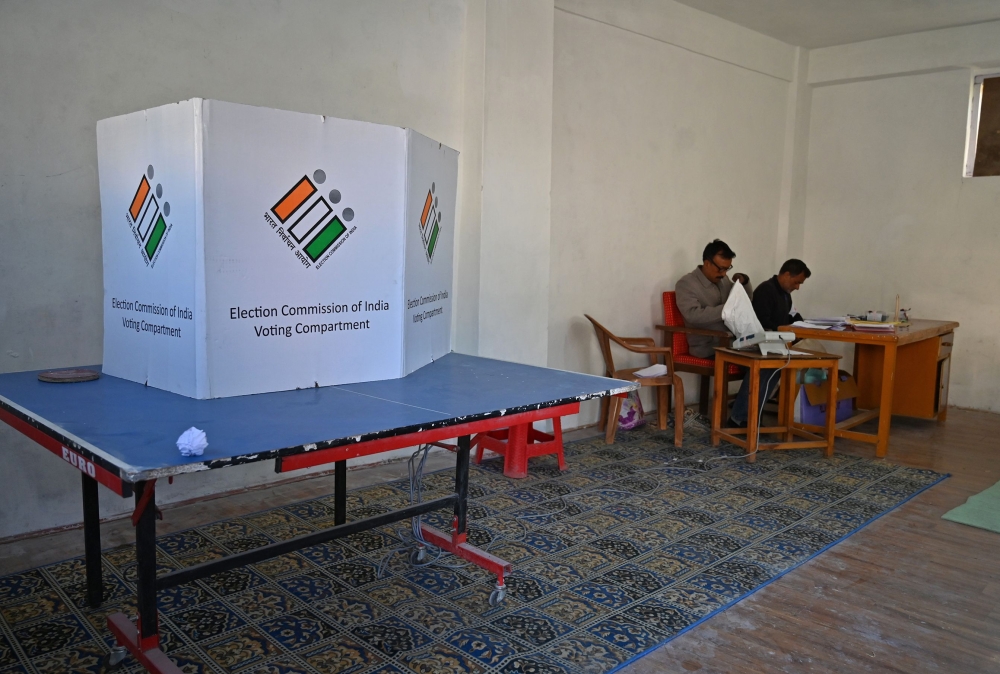 Election officials sit inside an empty polling station during the fifth phase of India's general elections in Kashmir's Shopian district, south of Srinagar, on May 6, 2019.  AFP / Tauseef MUSTAFA