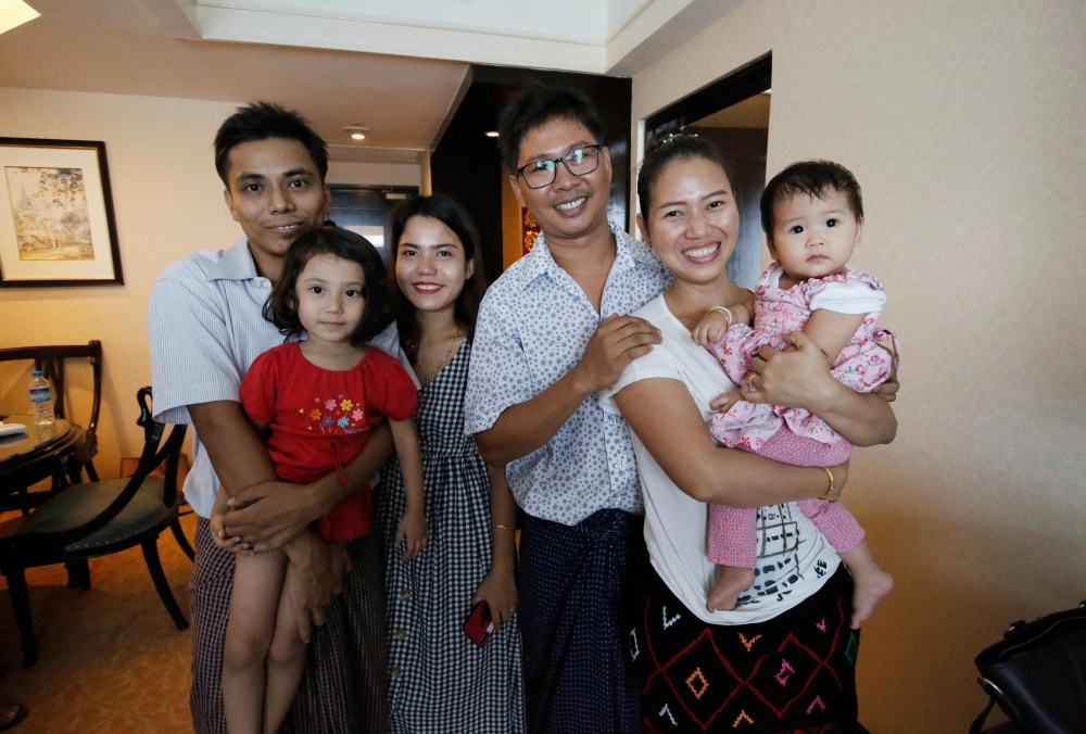 Reuters journalist Wa Lone (3rd R) poses with his wife Pan Ei Mon (2nd R) and daughter along with his colleague Kyaw Soe Oo (L) carrying his daughter and his wife Chit Su Win after being freed from prison in a presidential amnesty in Yangon on May 7, 2019
