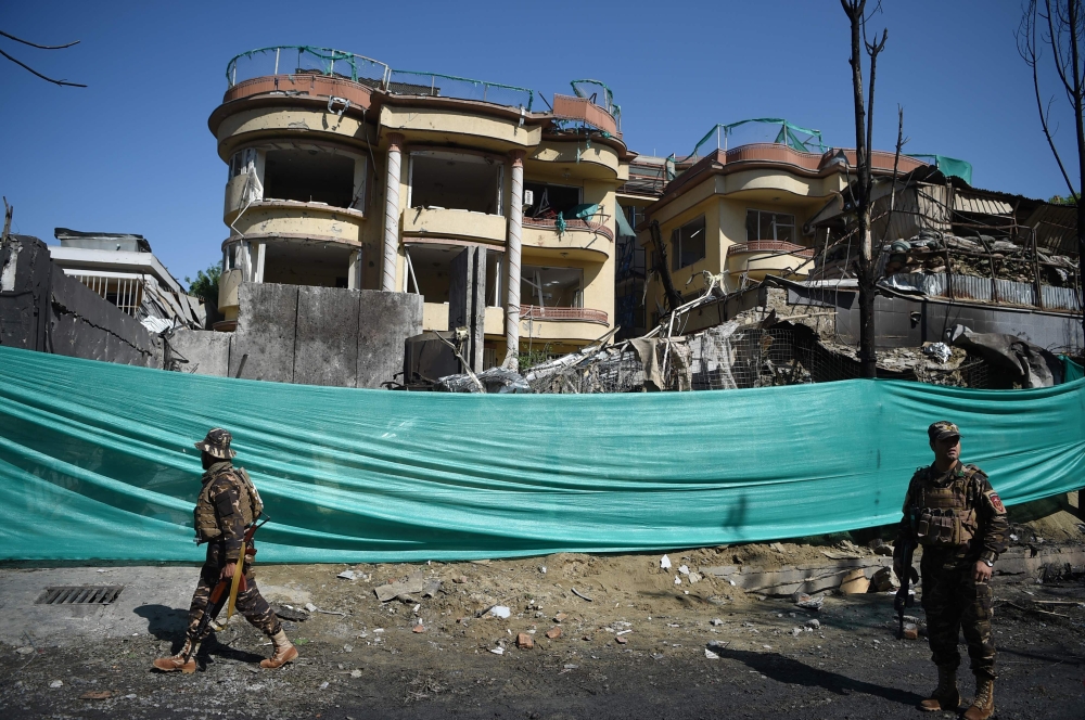 Afghan security forces stand at the site of an attack by Taliban militants, a day after the assault on a compound housing an international aid organisation, in Kabul on May 9, 2019.  AFP / WAKIL KOHSAR