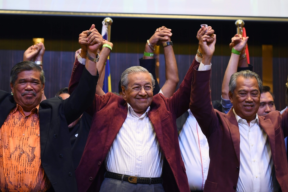 Mahathir Mohamad celebrates with other leaders of his coalition during a press conference following the 14th general elections in Kuala Lumpur on early May 10, 2018. AFP / Manan Vatsyayana