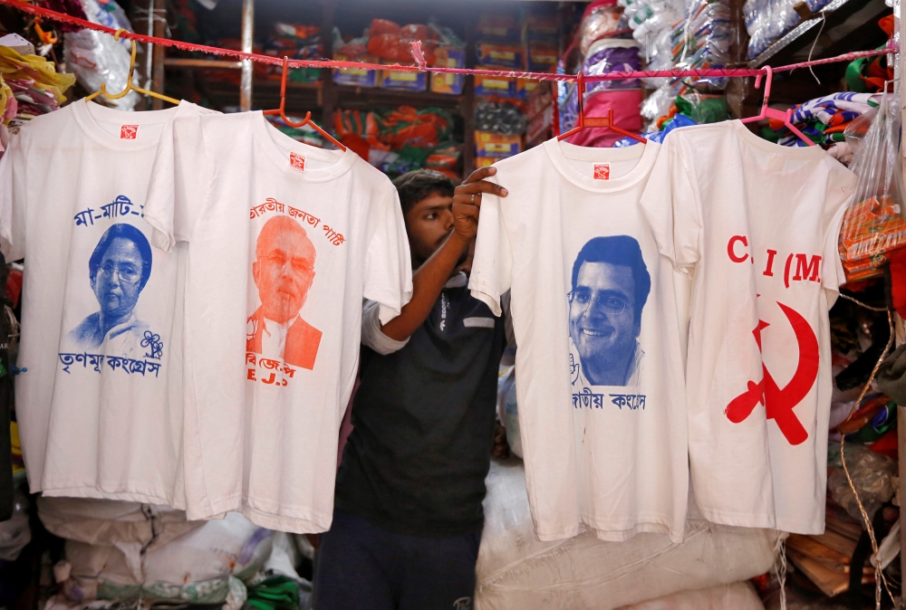 A worker displays T-shirts with images of Mamata Banerjee Narendra ModiM Rahul Gandhi and logo of CPI-M for sale inside a shop in Kolkata, India, March 26, 2019. Reuters / Rupak De Chowdhuri