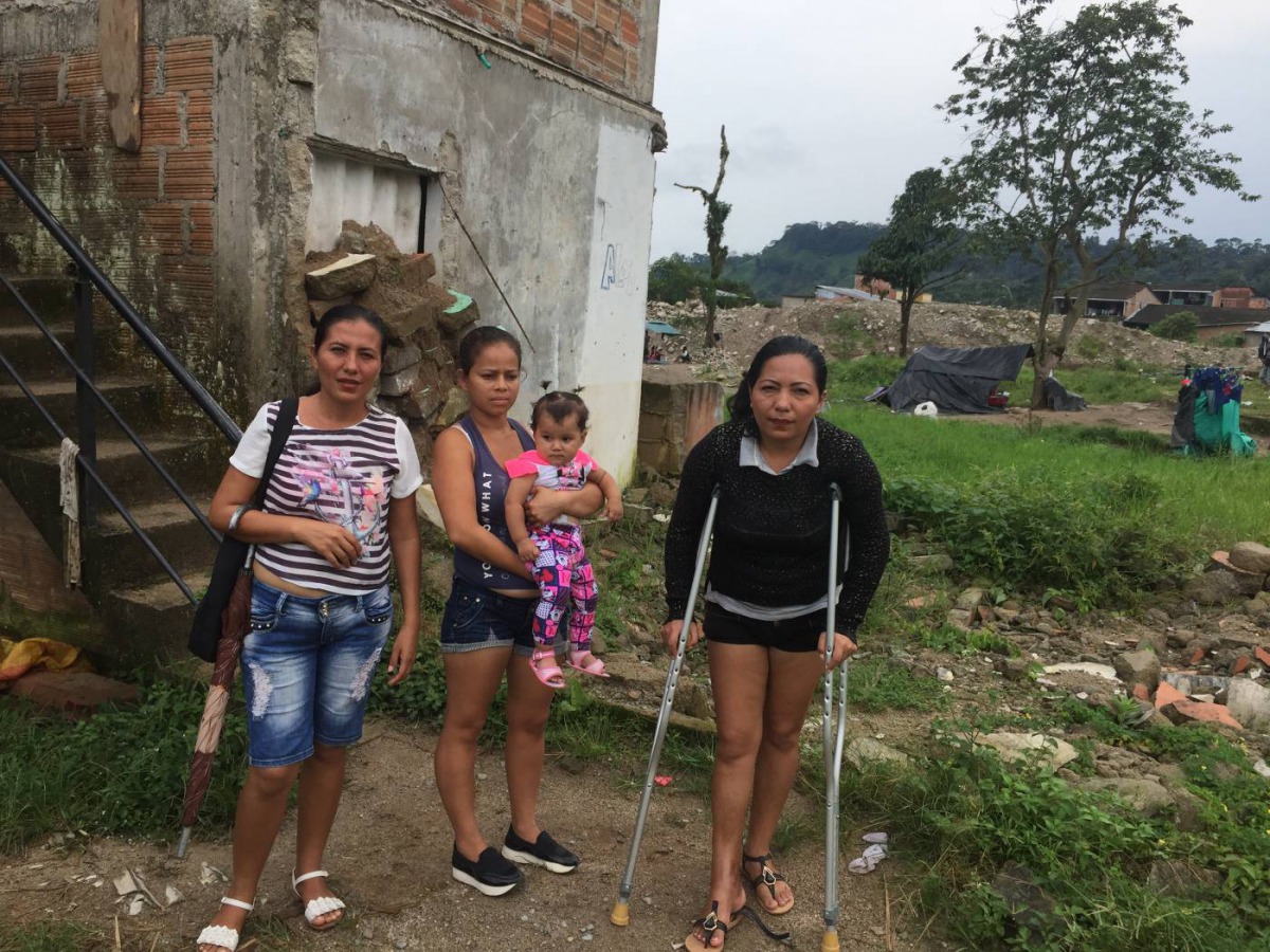 Landslide survivor Eugenia Torres and her friends stand behind a home in a flood prone area in Mocoa, Colombia, March 28, 2019. Thomson Reuters Foundation / Anastasia Moloney