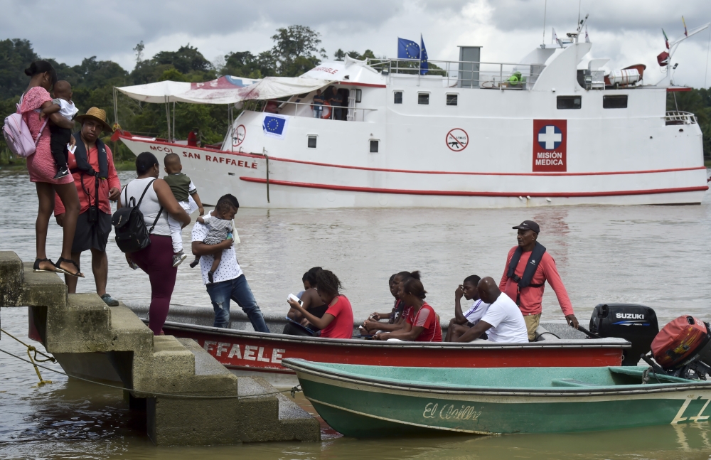 Locals get on a boat to the hospital ship 