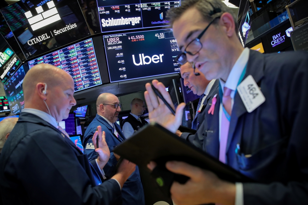Traders work near the post where Uber is traded on the floor at the New York Stock Exchange (NYSE) in New York, May 10, 2019. (REUTERS/Brendan McDermid)