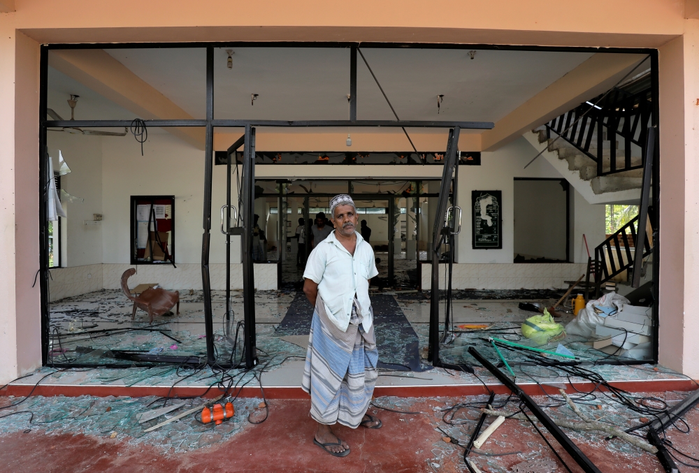 A man stands in front of the Abbraar Masjid mosque after a mob attack in Kiniyama, Sri Lanka May 13, 2019. (REUTERS/Dinuka Liyanawatte)