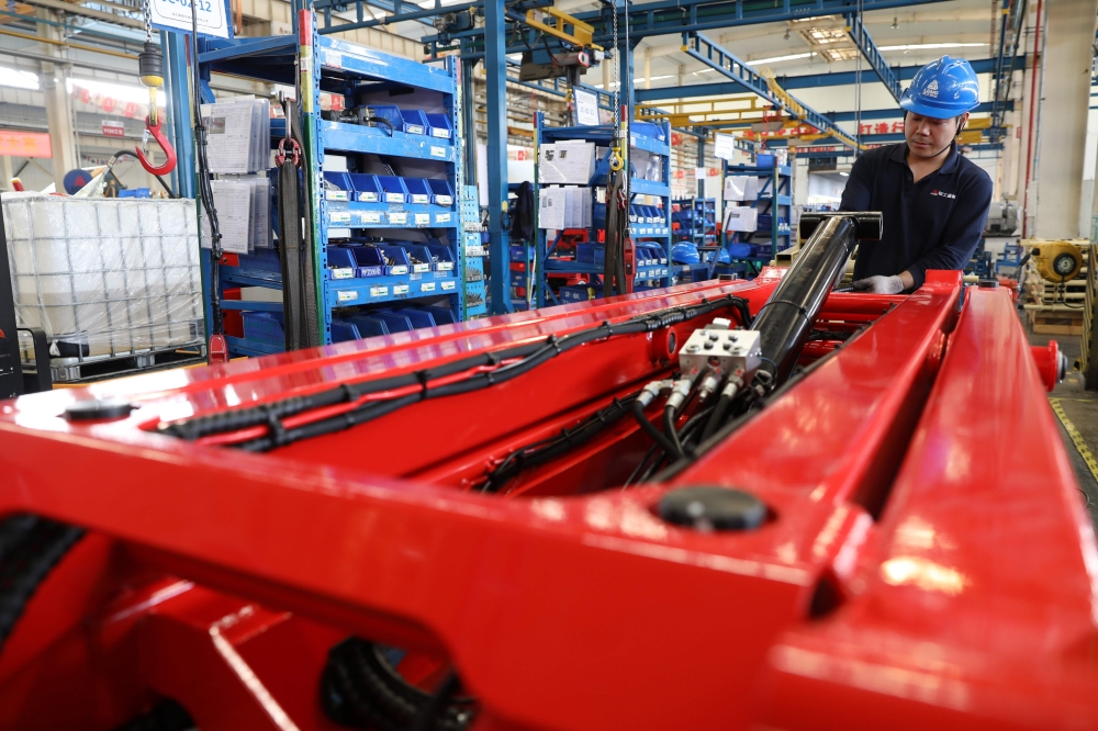 :This photo taken on May 11, 2019 shows a worker with a hydraulic lift at a factory producing construction machinery for export to many countries, including the US, in Jinan, in east China's Shandong province. (AFP)