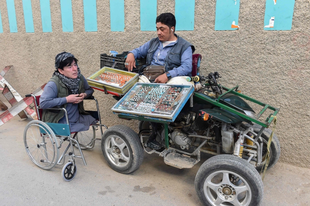 A Pakistani disabled vendor (R) belonging to the Shiite Hazara minority Muslim community waits for customers at a roadside in Hazara town, a neighbourhood in Quetta, on May 3, 2019. AFP / Banaras Khan