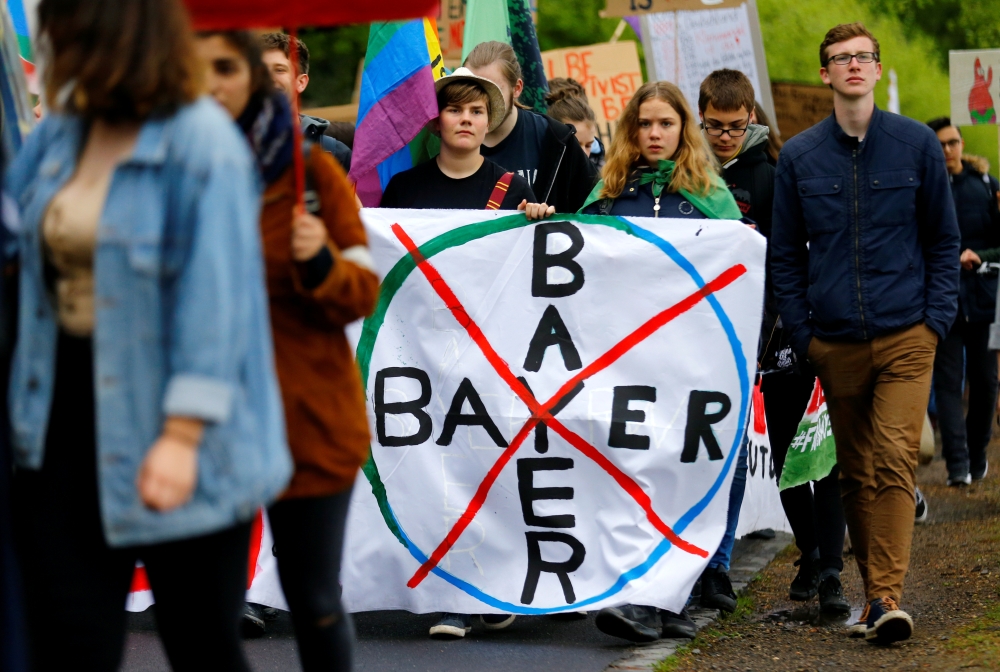 Environmental activists protesting against the merger of Germany's pharmaceutical and chemical maker Bayer AG with U.S. seeds and agrochemicals company Monsanto, march through Germany's former capital Bonn before Bayer's annual general shareholders meetin