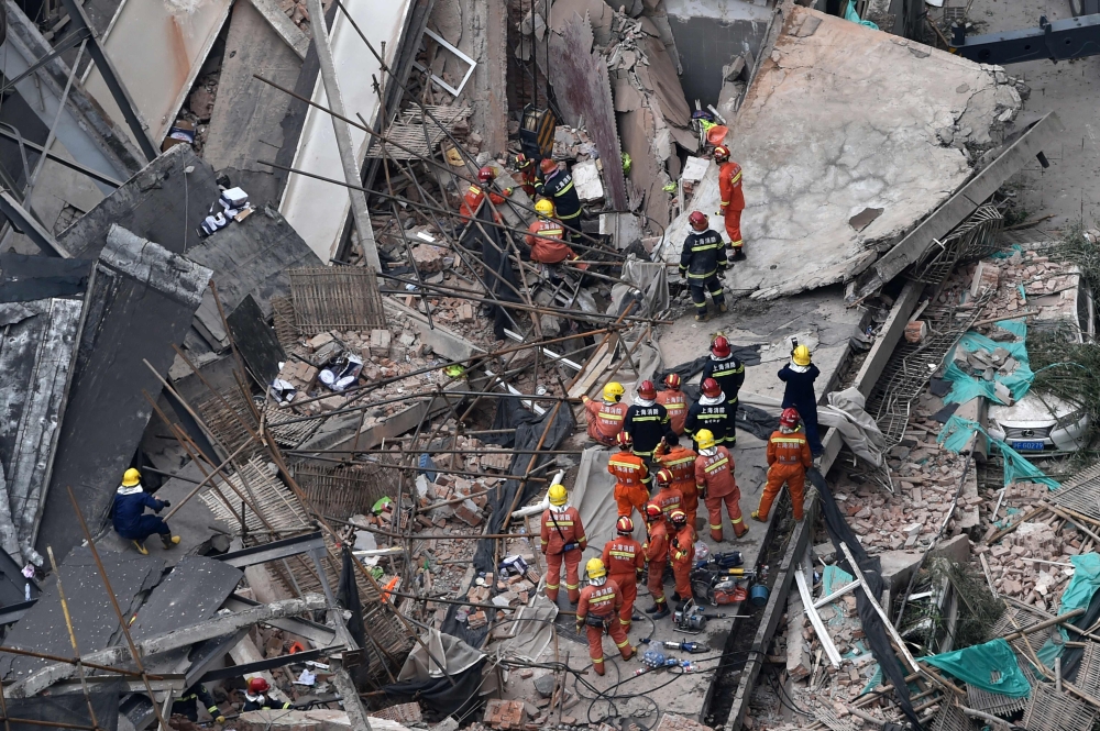Members of a rescue team work at the site of a building collapse in Shanghai on May 16, 2019. AFP / Hector RETAMAL