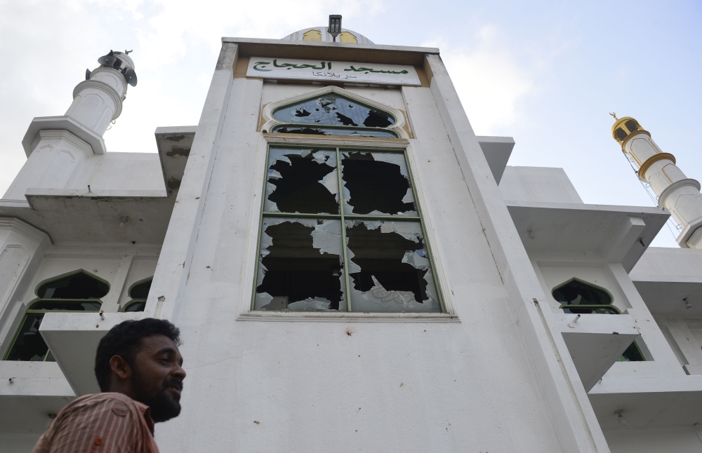 A Muslim man stands in front of the Jumha mosque after a mob attack in Minuwangoda on May 14, 2019. / AFP / LAKRUWAN WANNIARACHCHI 