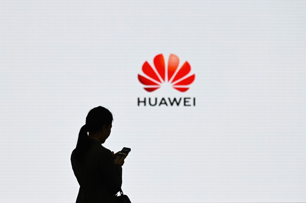 (FILES) In this file photo taken on March 6, 2019, a staff member of Huawei uses her mobile phone at the Huawei Digital Transformation Showcase in Shenzhen, China's Guangdong province. AFP / WANG ZHAO