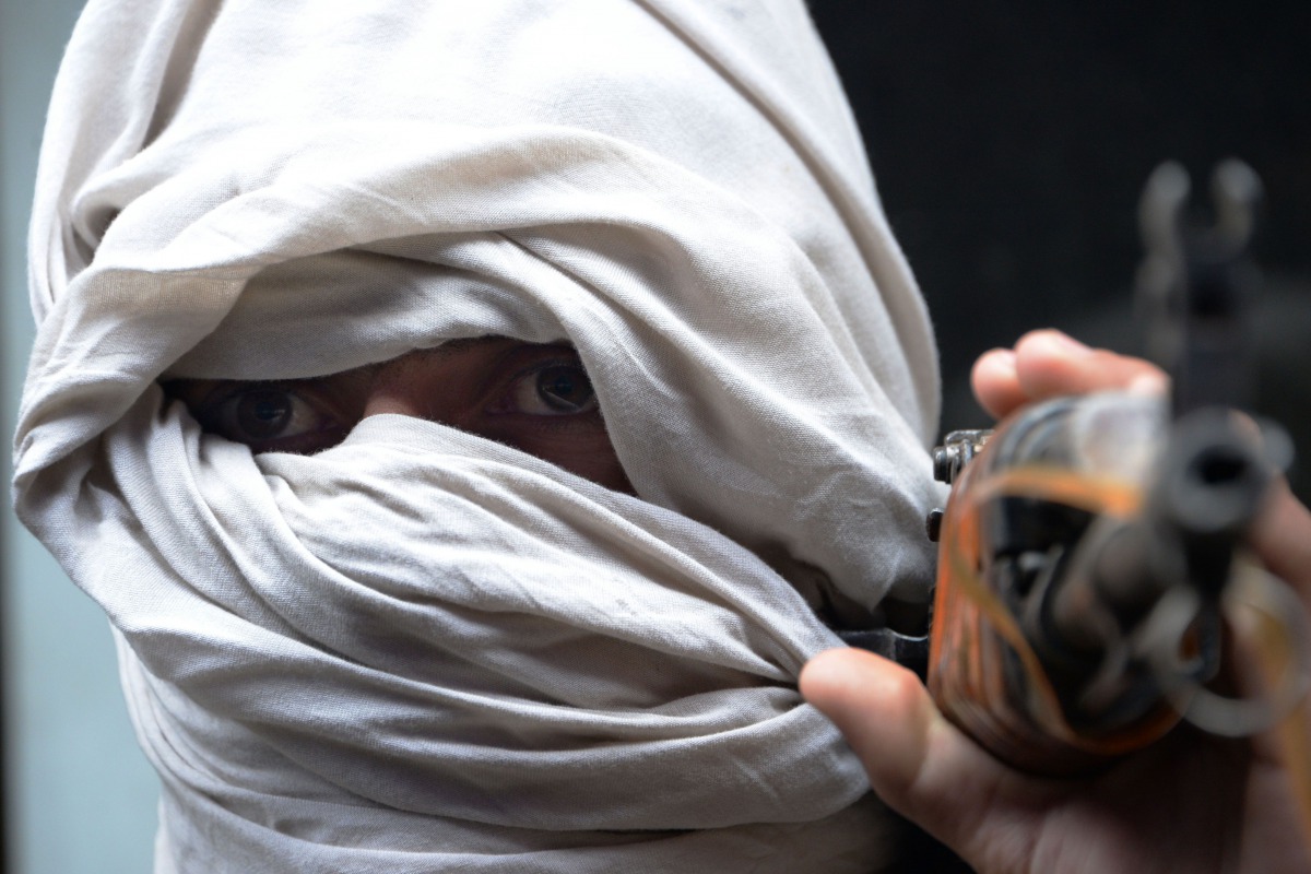 An Afghan former Taliban fighter carrying his weapon before handing it over as part of a government peace and reconciliation process at a ceremony in Jalalabad, January 12, 2016. AFP/Noorullah Shirzada