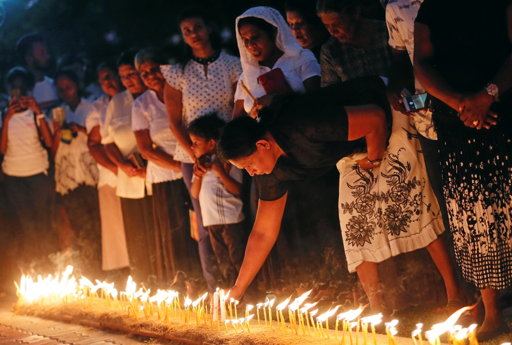 Devotees light candles while praying in front of St. Sebastian church, one of the churches attacked in the April 21st Easter Sunday Islamic militant bombings, during the first-month remembrance service in Negombo, Sri Lanka May 21, 2019. REUTERS/Dinuka Li