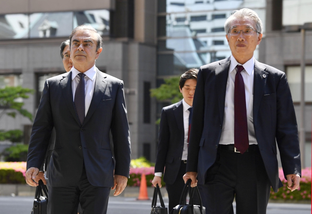 Former Nissan Motor Co. Chairman Carlos Ghosn and his lawyer Junichiro Hironaka arrive at the Tokyo District Court for the first pretrial procedures in his financial misconduct case, in Tokyo, Japan, May 23, 2019, in this photo taken by Kyodo