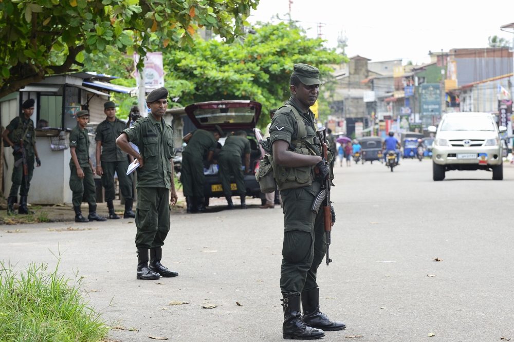 Sri Lankan army soldiers stands guard at a checkpoint on a roadside during special cordon-and-search operations in Colombo on May 25, 2019. AFP / LAKRUWAN WANNIARACHCHI