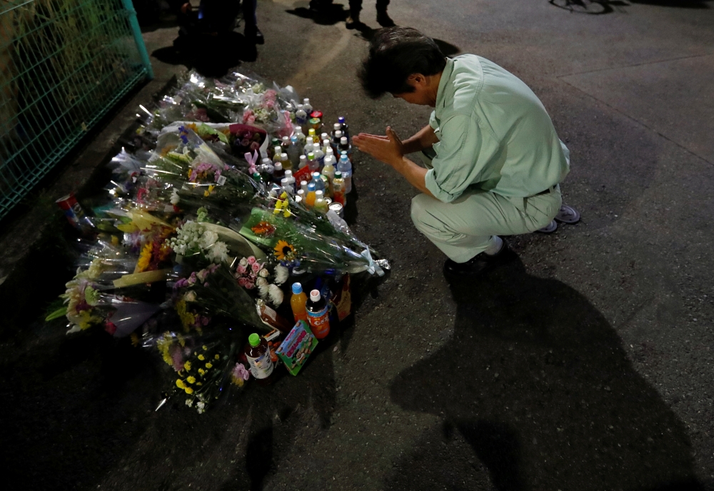 A local resident prays to mourn victims at the site where a stabbing occured in Kawasaki, Japan, May 28, 2019. REUTERS/Issei Kato