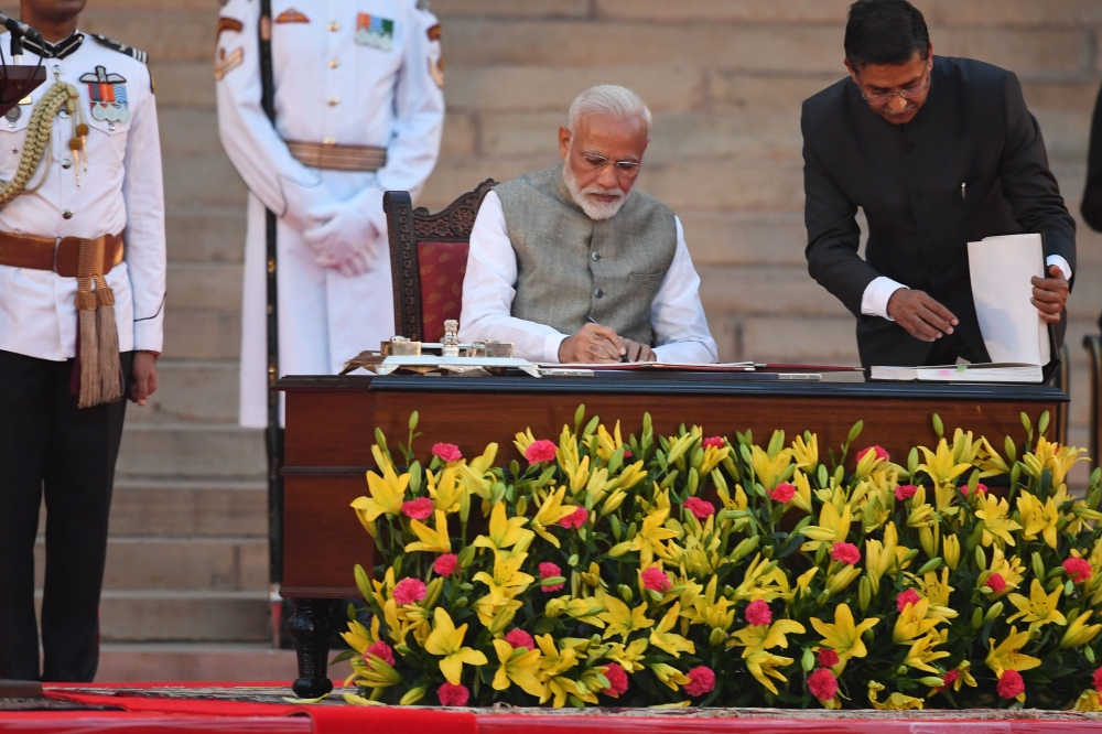 Narendra Modi signs documents after taking the oath of office as India's Prime Minister at the President house in New Delhi on May 30, 2019. / AFP / PRAKASH SINGH 