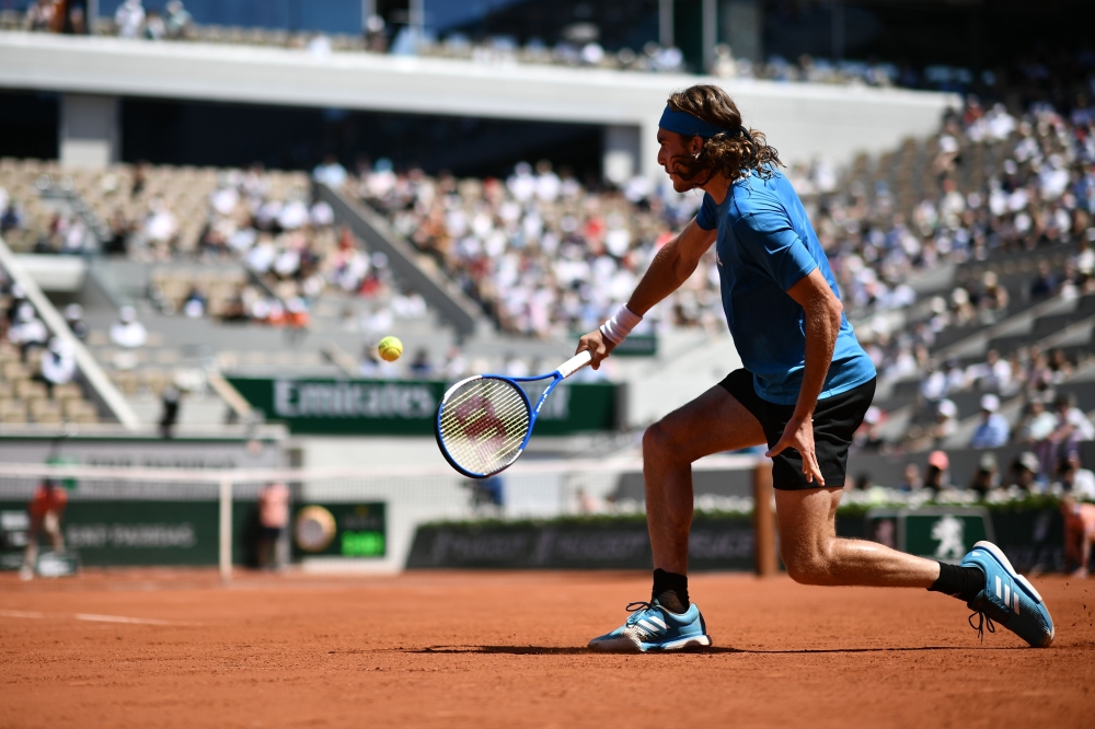 :Greece's Stefanos Tsitsipas returns the ball to Serbia's Filip Krajinovic during their men's singles third round match on day seven of The Roland Garros 2019 French Open tennis tournament in Paris on June 1, 2019. / AFP / Philippe LOPEZ
