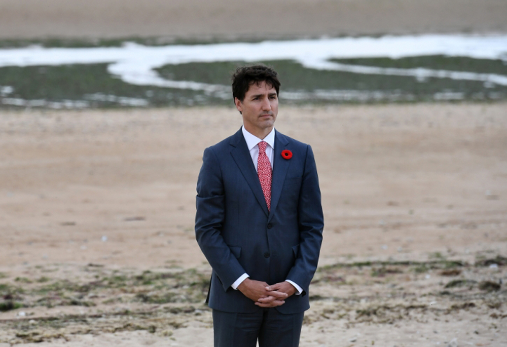 Canadian Prime Minister Justin Trudeau stands after laying a wreath during an international D-Day commemoration ceremony on Juno Beach in Courseulles-sur-Mer, France June 6, 2019. Fred Tanneau/Pool via REUTERS