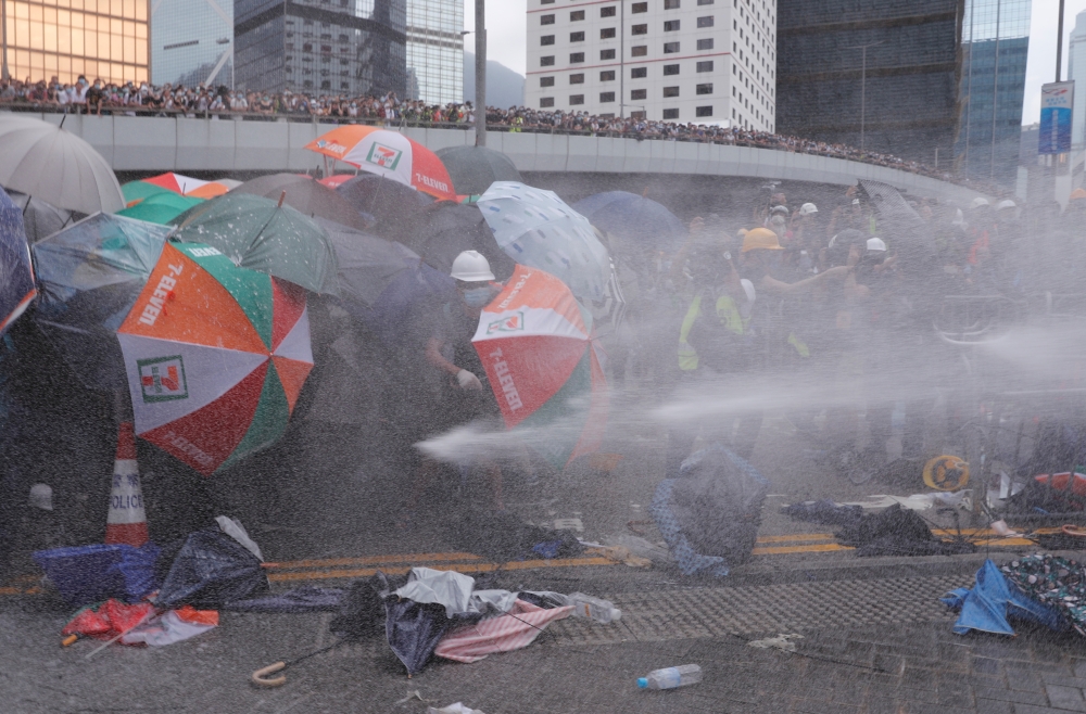 Protesters are hit by police water cannon during a demonstration against a proposed extradition bill in Hong Kong, China June 12, 2019. REUTERS/Tyrone Siu