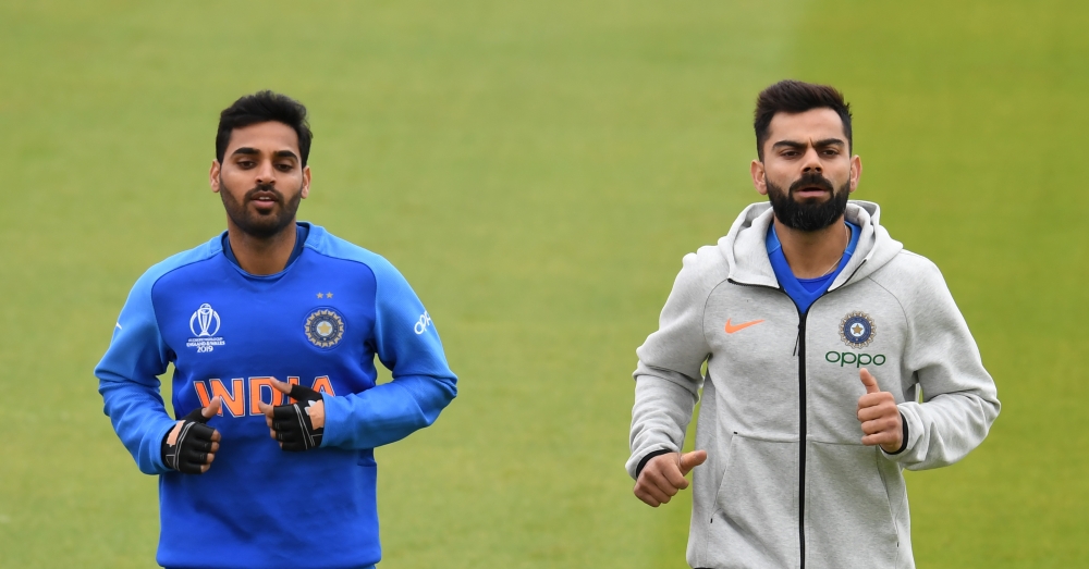 India's Bhuvneshwar Kumar (L) and India's captain Virat Kohli jog during a training session at Old Trafford Cricket Stadium in Manchester on June 15, 2019, ahead of their 2019 World Cup match against Pakistan. AFP / Dibyangshu Sarkar 