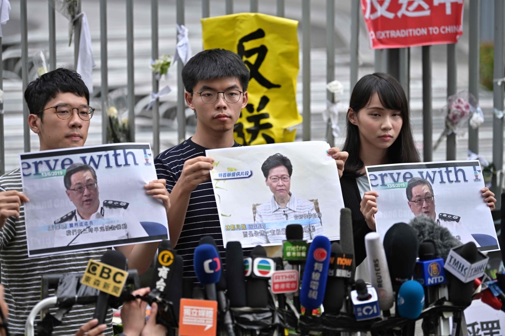 Members of pro-democracy party Demosisto (L-R) Nathan Law, Joshua Wong and Agnes Chow speak to the media after Chief Executive Carrie Lam held a press conference in Hong Kong on June 18, 2019.  AFP / Anthony WALLACE