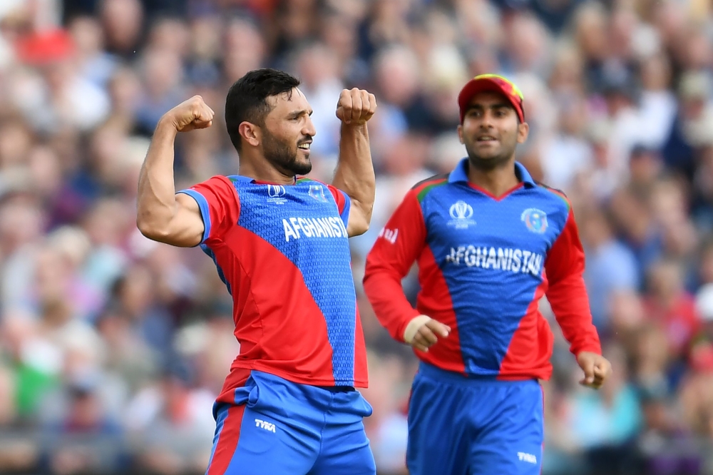 Afghanistan's captain Gulbadin Naib celebrates (L) taking the wicket of England's Jonny Bairstow for 90 runs during the 2019 Cricket World Cup group stage match between England and Afghanistan at Old Trafford in Manchester, northwest England, on June 18, 