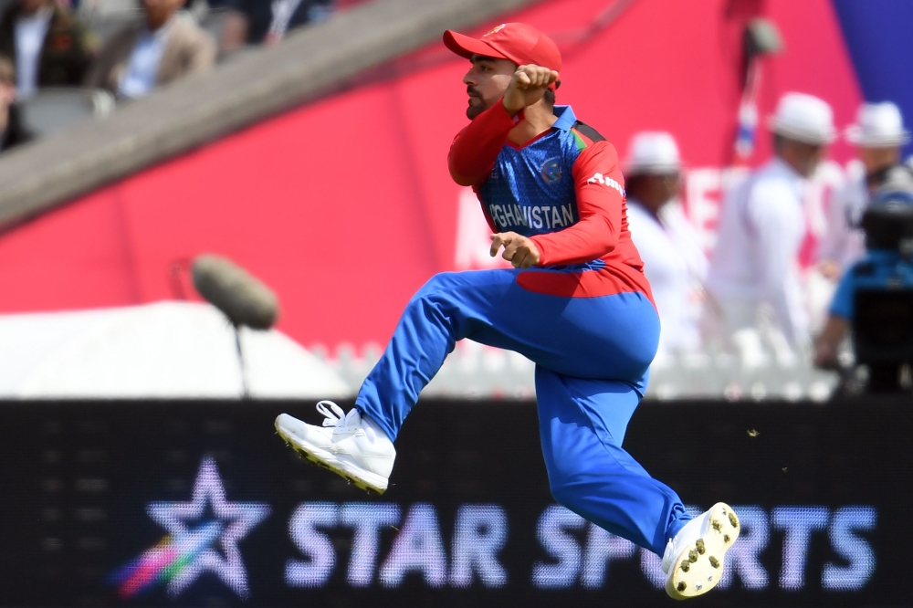 Afghanistan's Rashid Khan jumps as he fields the ball during the 2019 Cricket World Cup group stage match between England and Afghanistan at Old Trafford in Manchester, northwest England, on June 18, 2019. AFP / Dibyangshu Sarkar