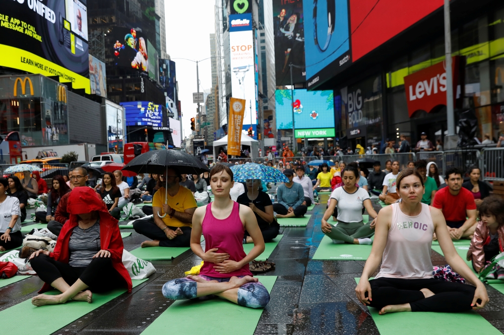 Yogis participate in a yoga class during the annual Solstice in Times Square event in New York, U.S., June 21, 2019. Reuters/Shannon Stapleton