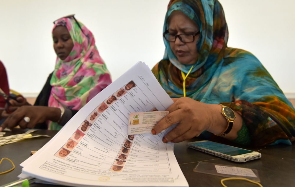 An election official checks for a voter name on the electoral list at a polling station on June 22, 2019, in Nouakchott during Mauritania's presidential election. AFP / Sia KAMBOU