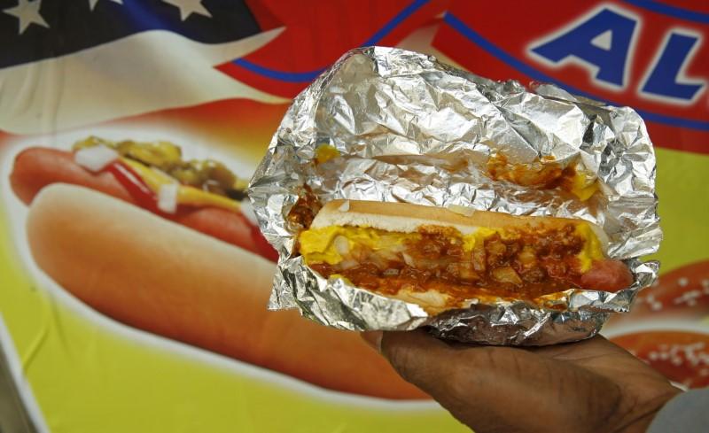 A man holds out a hot dog he bought from a street vendor in Washington October 26, 2015. Reuters/Kevin Lamarque