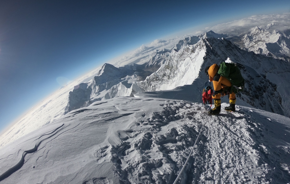 In this file photo taken on May 17, 2018 mountaineers make their way to the summit of Mount Everest, as they ascend on the south face from Nepal.  AFP / Phunjo Lama
 