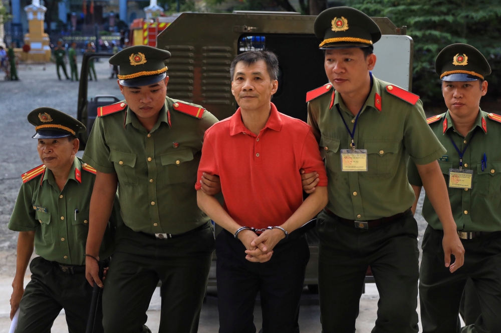 US citizen Michael Nguyen is escorted by policemen before his trial at a court in Ho Chi Minh city, Vietnam June 24, 2019. REUTERS/Stringer