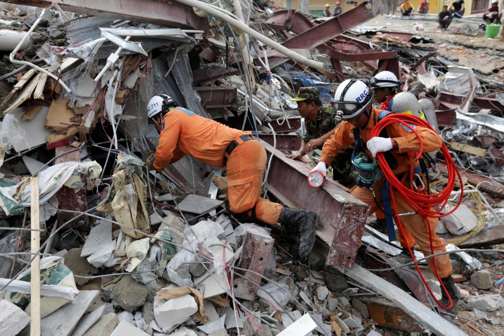 Rescue workers search for victims in the debris a day after an under-construction building collapsed in Sihanoukville on June 23, 2019. / AFP / SUN RETHY Kun
 