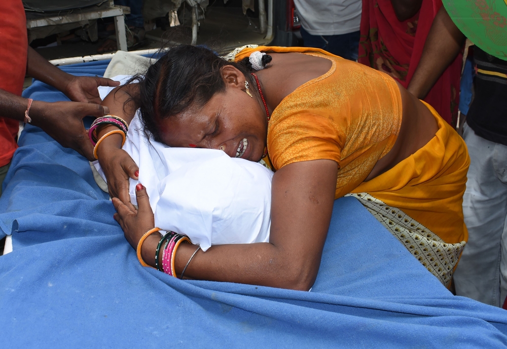 An Indian woman mourns with the wrapped up body of Muskan Sahni who had earlier died from Acute Encephalitis Syndrome (AES) at the government-run Sri Krishna Medical College and Hospital in Muzaffarpur district in the eastern state of Bihar on June 19, 20