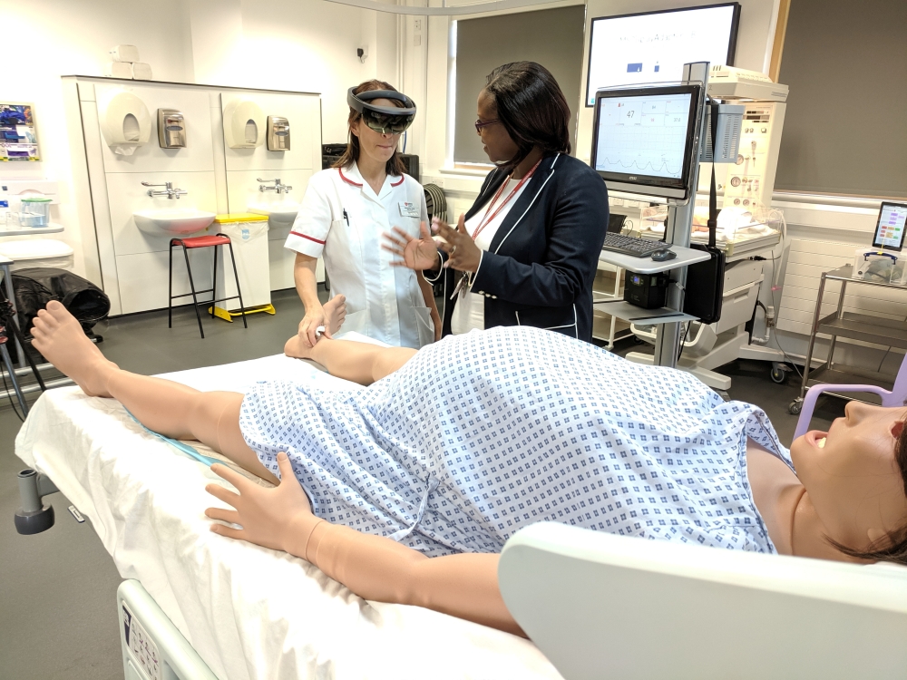 Midwifery educator at Middlesex University Sarah Chitongo instructs a trainee midwife wearing an augmented reality (AR) headset in London, Britain June 17, 2019.  Reuters/Stuart McDill