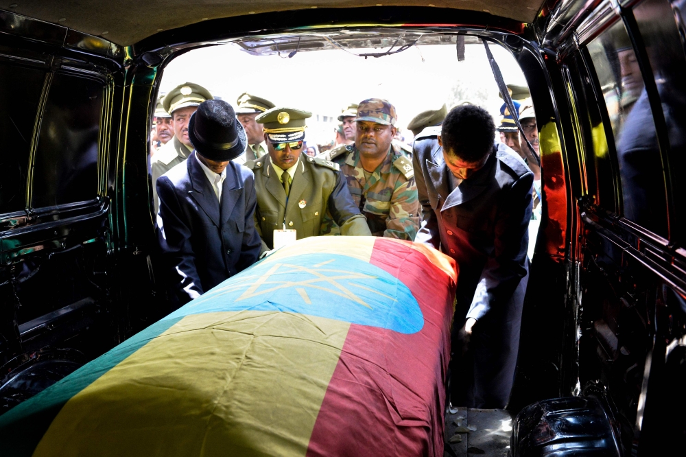 Members of the army carry one of the coffins covered with the Ethiopian national flag as they arrive at the millennium hole in Addis Ababa, on June 25, 2019 for the National funeral service of Chief of Staff of the Ethiopian defence forces Seare Mekonnen 