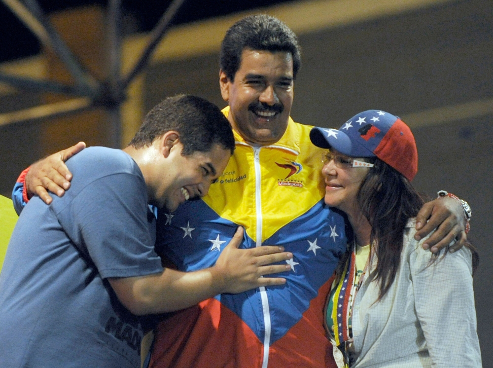  In this file photo taken on April 06, 2013, Venezuelan acting President Nicolas Maduro (C) embraces his wife Cilia Flores (L) and son Nicolas Maduro during a campaign rally in Puerto Ordaz, Bolivar state, Venezuela.  AFP / Juan Barreto
 