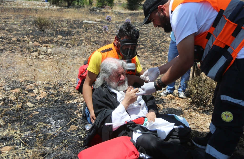 Health team evacuate an injured protestor after Israeli security forces' intervention to a protest against the U.S.-led conference in Bahrain, at Beit El checkpoint in Ramallah, West Bank on June 25, 2019. (?ssam Rimawi/Anadolu Agency)