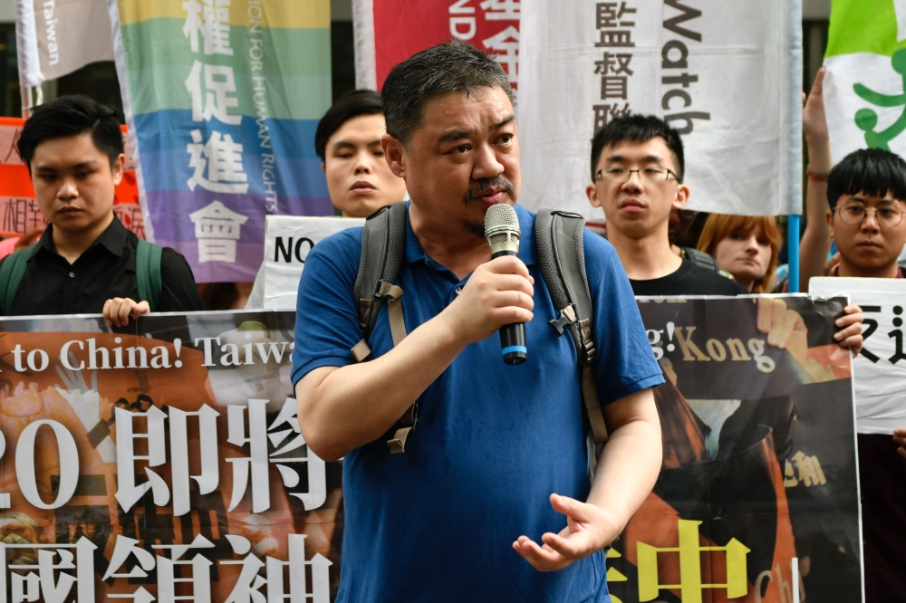 Chinese dissident Wuer Kaixi (C) speaks during a rally outside the Hong Kong Economic, Trade and Culture office in Taipei on June 27, 2019, calling for leaders of G20 nations to confront fellow member China following massive protests in Hong Kong against 