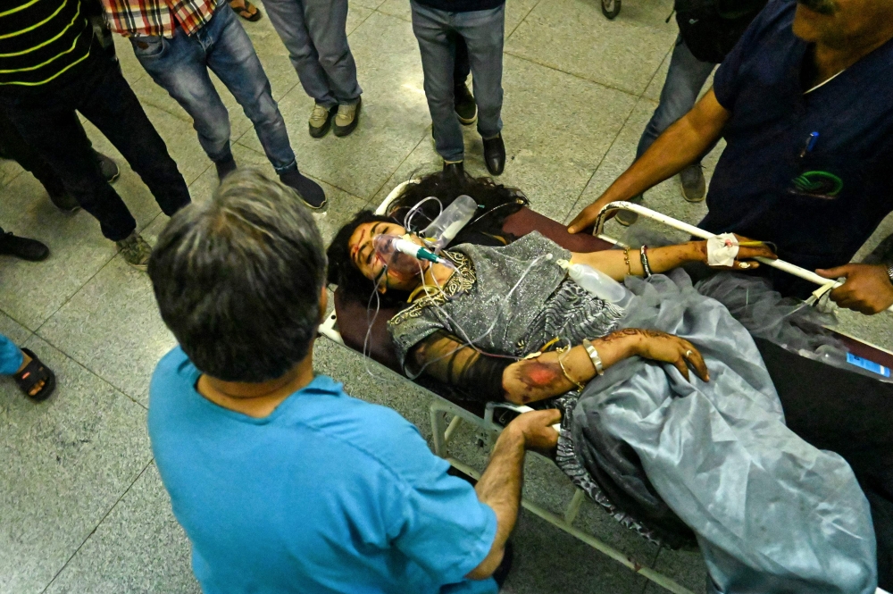 Kashmiri volunteers and medical staff move on a stretcher a girl injured on a road accident after a vehicle fell into a gorge along the Mughal road in south Kashmir’s Shopian district, at a hospital in Srinagar on June 27, 2019. AFP / Tauseef Mustafa 