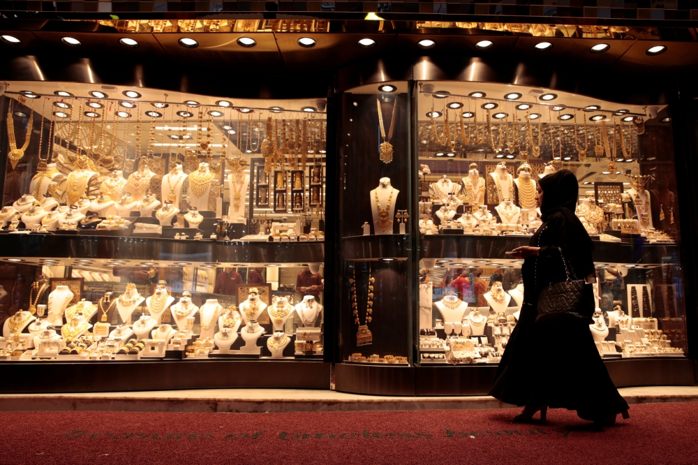 A woman walks past gold jewellery displayed in a shop window at the Gold Souq in Dubai, March 24, 2018. Reuters/Christopher Pike