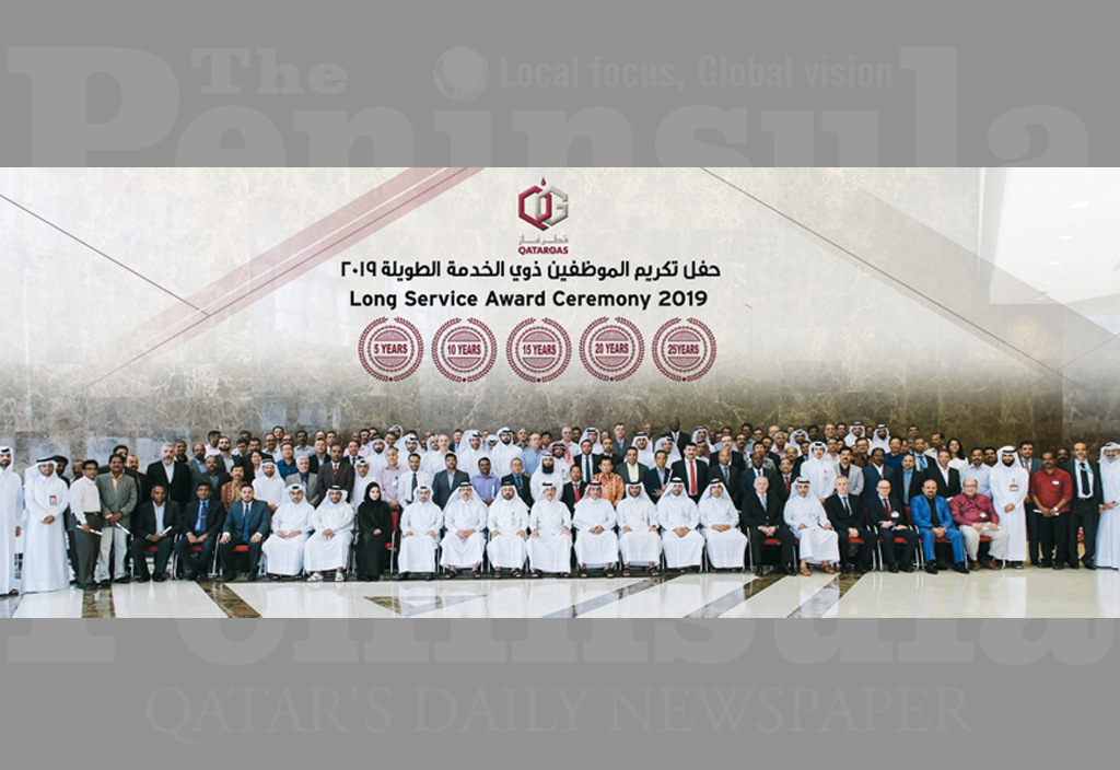 Qatargas officials and the long-serving employees posing for a group picture.