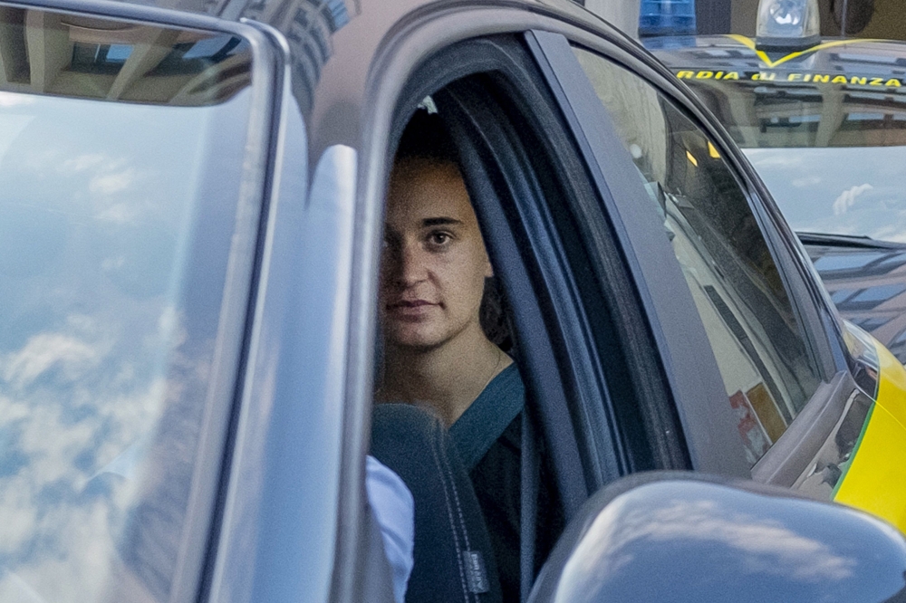 German captain of humanitarian ship Sea-Watch 3, Carola Rackete (Rear in car) looks on as she leaves in a car of the Italian Guardia di Finanza law enforcement agency on July 1, 2019 after appearing before a judge at the courthouse in Agrigento, Sicily. A