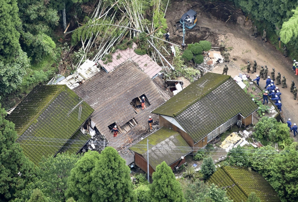 An aerial view shows rescue workers searching for a missing resident at a collapsed house due to a landslide caused by heavy rain in Soo, Kagoshima prefecture, southwestern Japan, July 4, 2019, in this photo taken by Kyodo. Mandatory credit Kyodo/via Reut