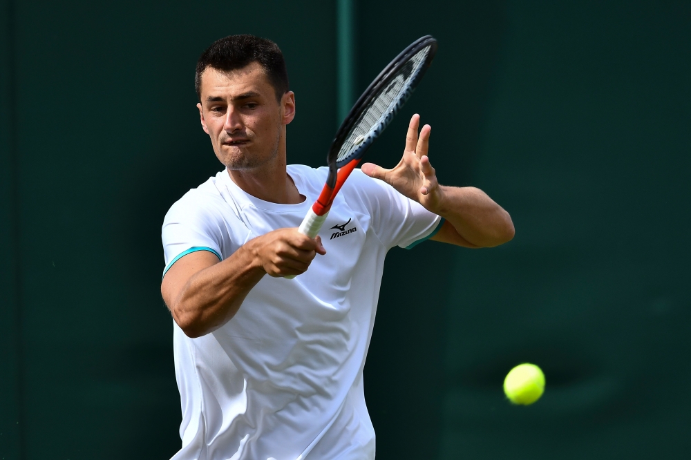 Australia's Bernard Tomic returns against France's Jo-Wilfried Tsonga during their men's singles first round match on the second day of the 2019 Wimbledon Championships at The All England Lawn Tennis Club in Wimbledon, southwest London, on July 2, 2019. A