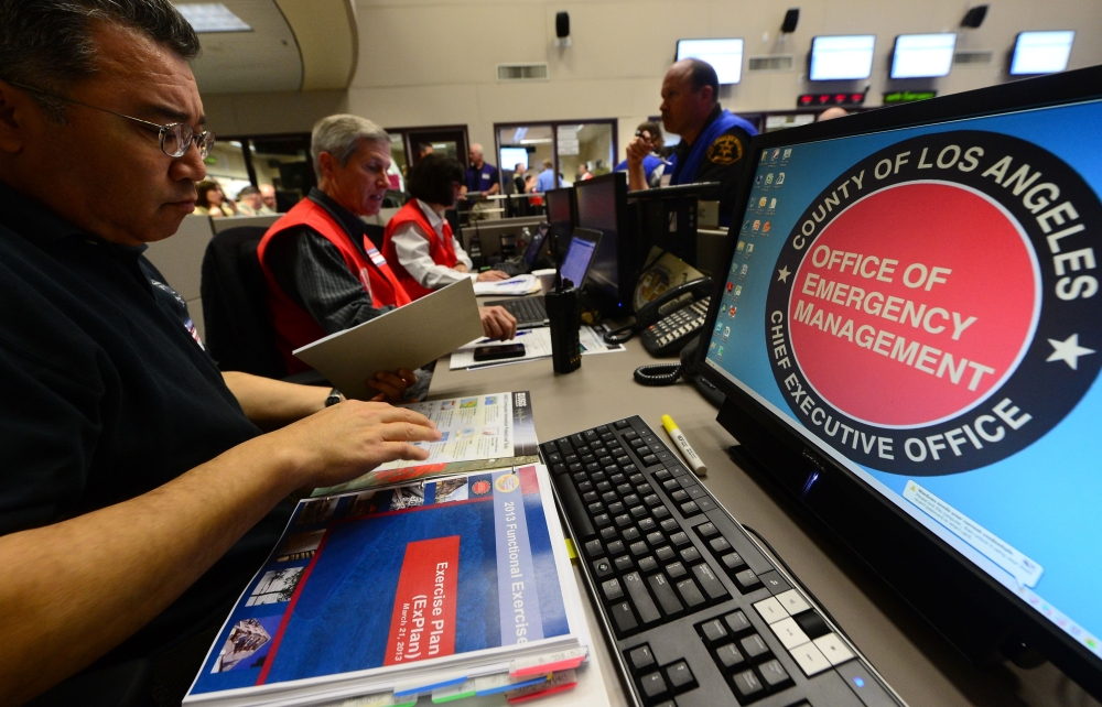 Participants from the I.T (L) and Disaster Management (C/R) work side by side at the Command Center of the Office of Emergency Management in Los Angeles, California, during a functional exercise for first responders in a simulated 7.8 magnitude earthquake
